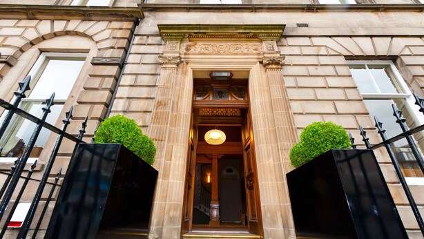 A grand entrance with a large, ornate doorway, flanked by two black gates. - The Place (Edinburgh)