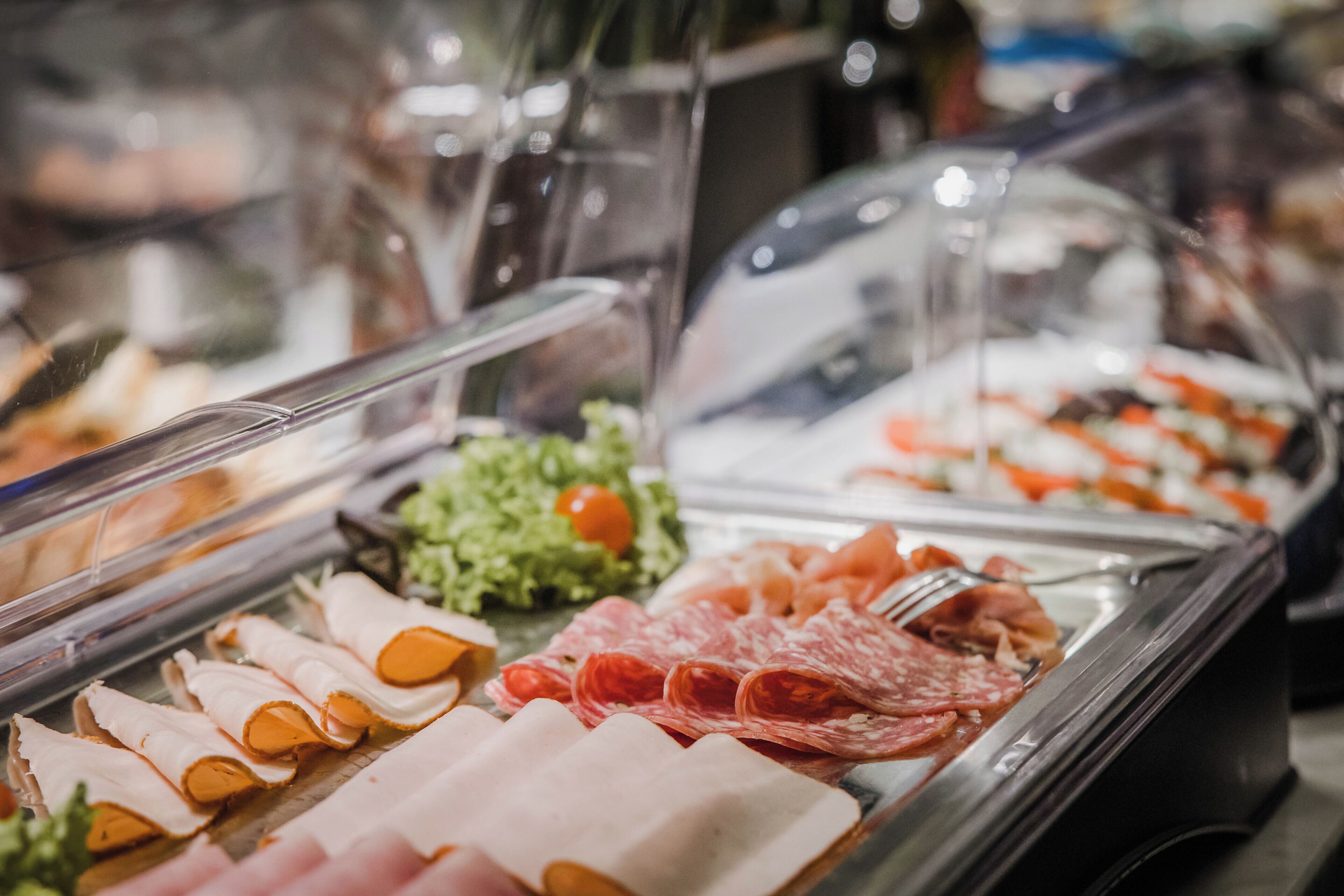 Een buffet met verschillende vleessoorten en groenten.