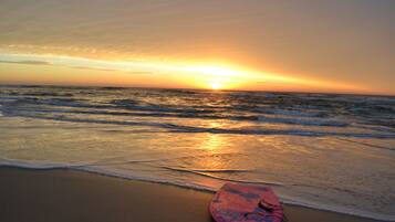 In Strandnähe, weißer Sandstrand, Sonnenschirme, Strandtücher