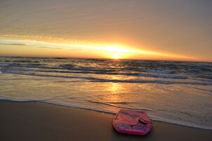 Una playa cerca, arena blanca, sombrillas, toallas de playa
