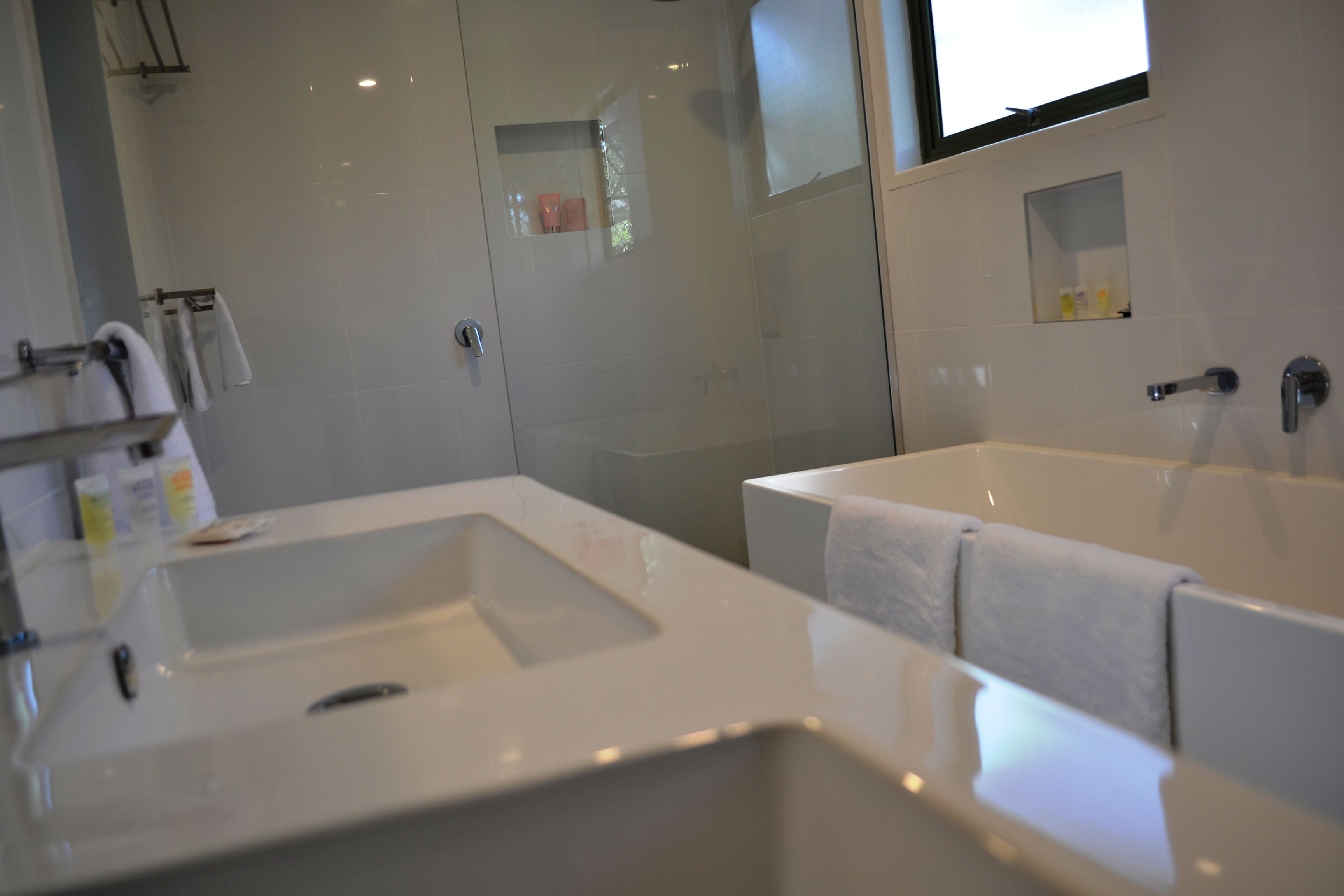 Une salle de bain moderne avec un grand lavabo, une baignoire et un espace douche.
