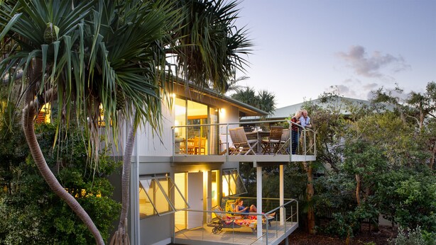 Une maison moderne dotée d’un balcon et d’un espace extérieur couvert.