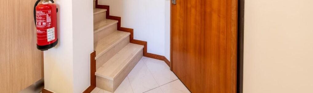 A staircase with a fire extinguisher mounted on the wall.