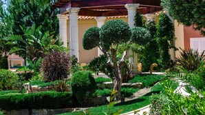 A garden with a pergola, columns, and various plants. - Baia da Luz (Lagos)
