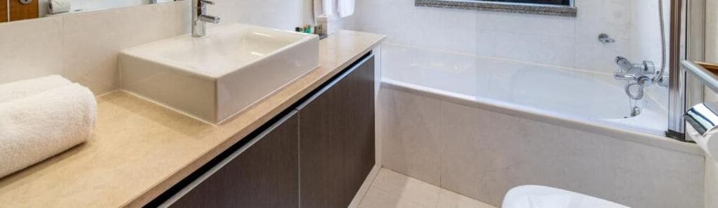 A modern bathroom with a large bathtub, a sink, and a toilet.