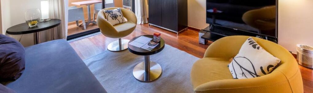 Ein modernes Wohnzimmer mit einer Couch, zwei Sesseln, einem Couchtisch und einem Kamin.