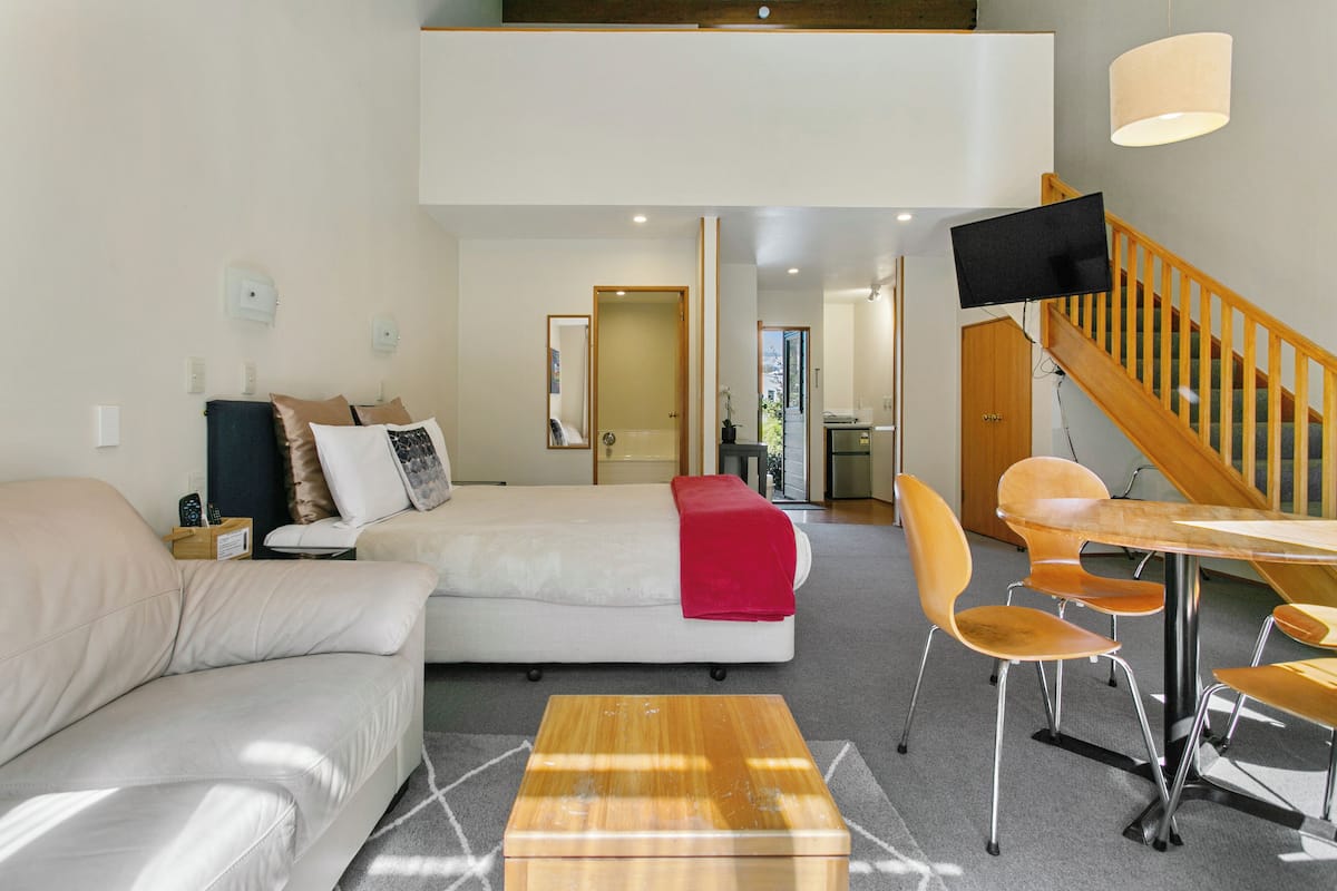 Un salon moderne avec un canapé, une table basse et un coin repas avec des chaises.