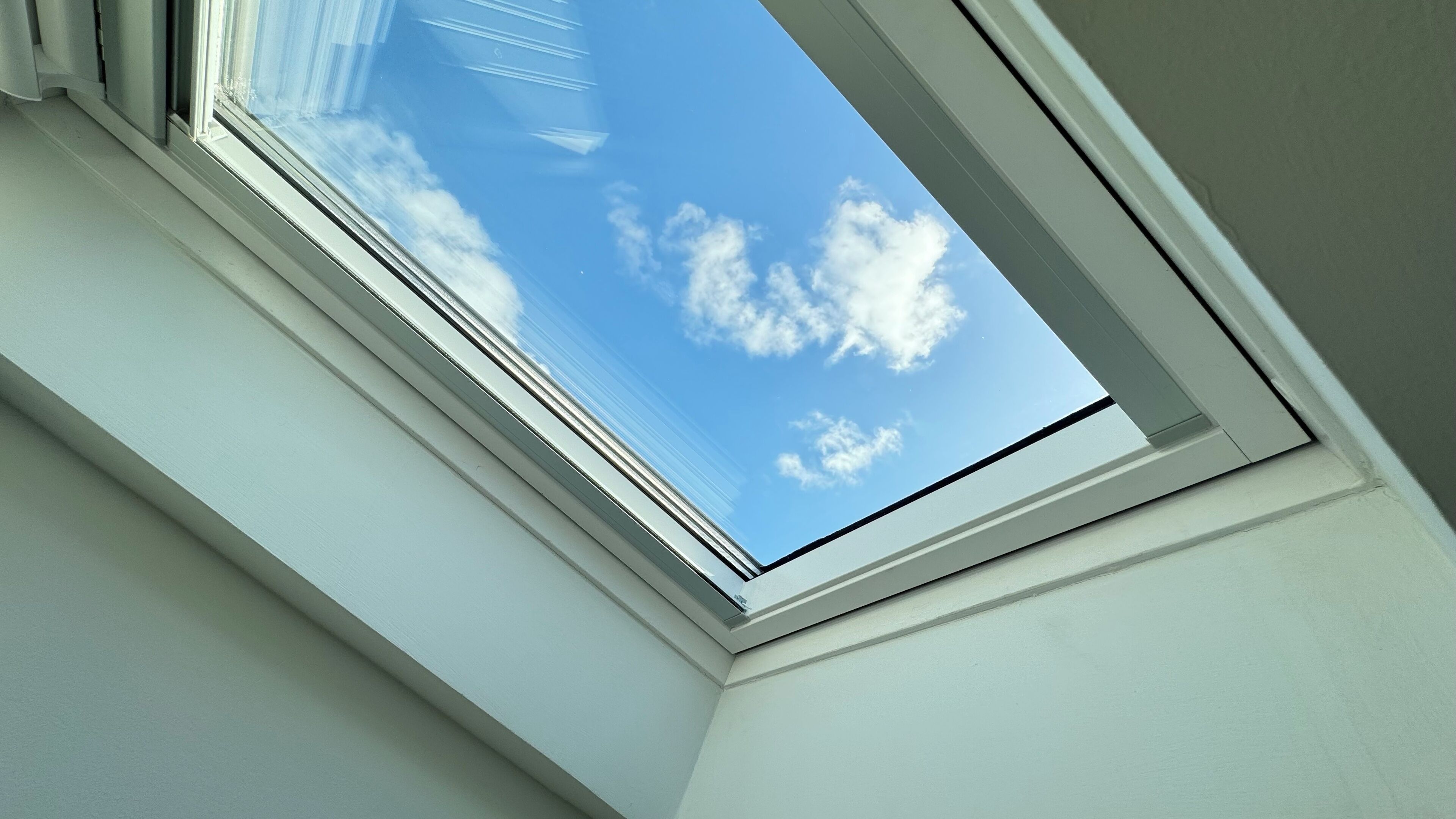 Une lucarne offrant une vue dégagée sur un ciel bleu.