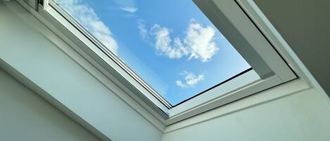 Une lucarne offrant une vue dégagée sur un ciel bleu.