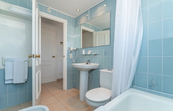 A bathroom with a sink, toilet, and bathtub.
