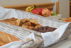 A wicker basket filled with pastries, fruits, and a bowl of apples. - Hotel Platja D'aro (Castell-Platja d'Aro)