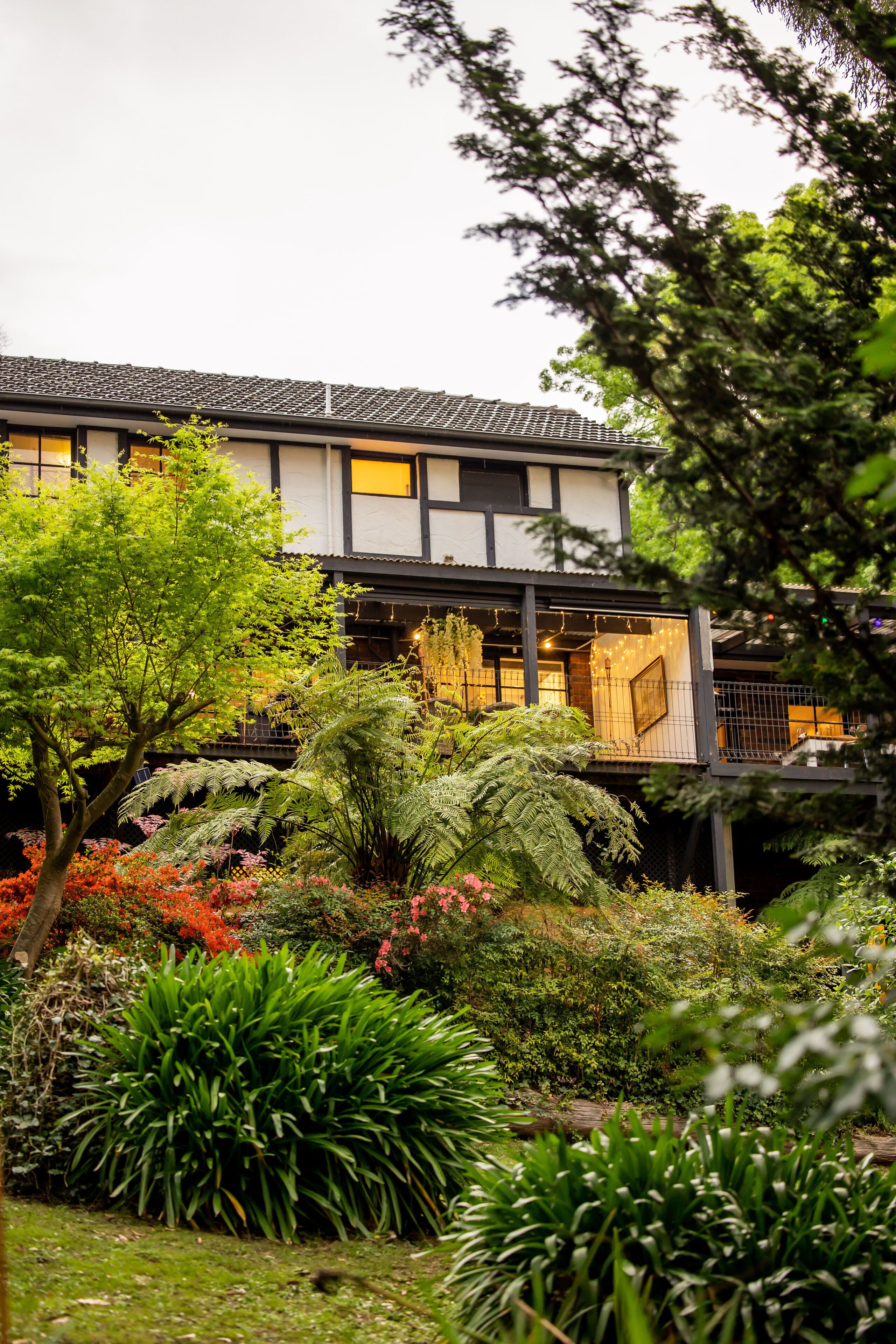 Il s'agit d'un bâtiment de style japonais traditionnel, doté d'un jardin à l'avant, où l'on trouve une variété de plantes et un petit étang.