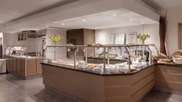 A buffet area with various food items and a vase of tulips.