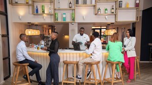 A bar area with stools, a counter, and shelves with bottles. - Illovo Hotel (Sandton)