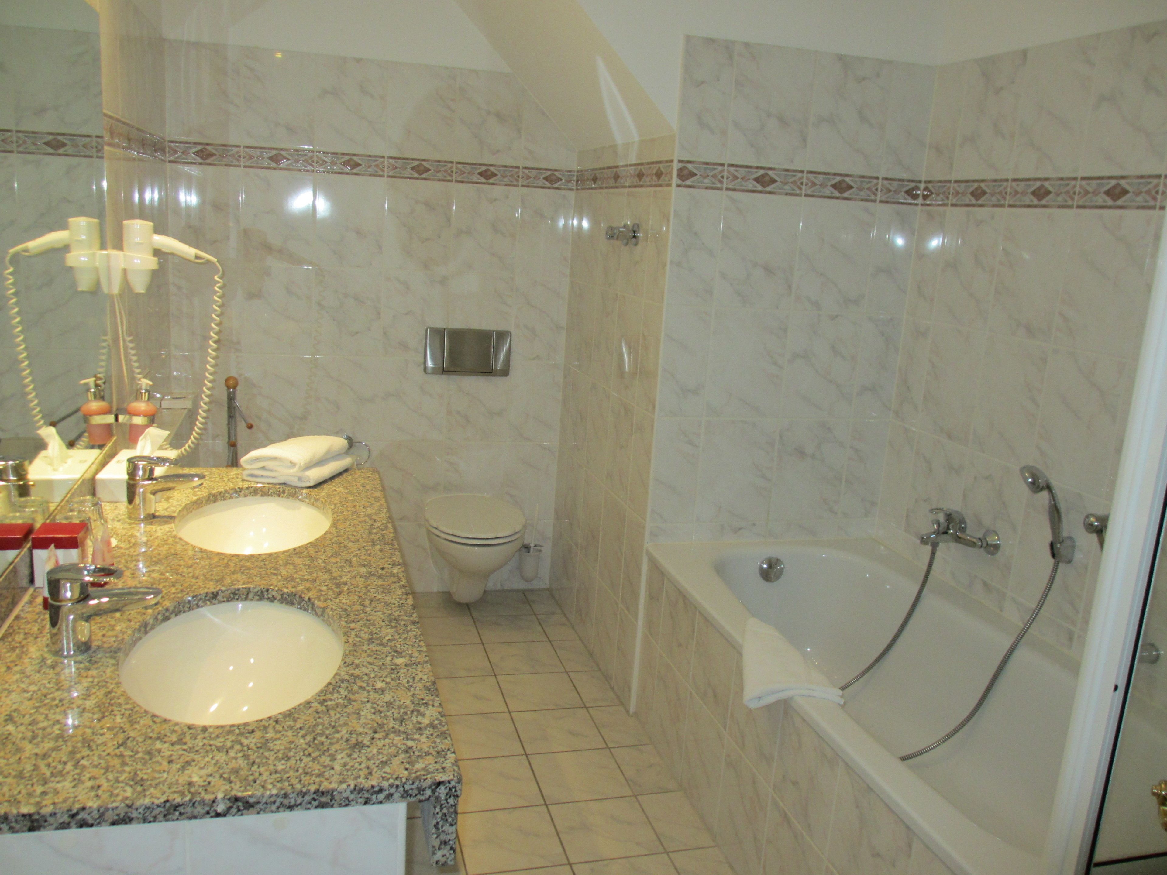 Un baño con dos lavamanos, un inodoro y una bañera.
