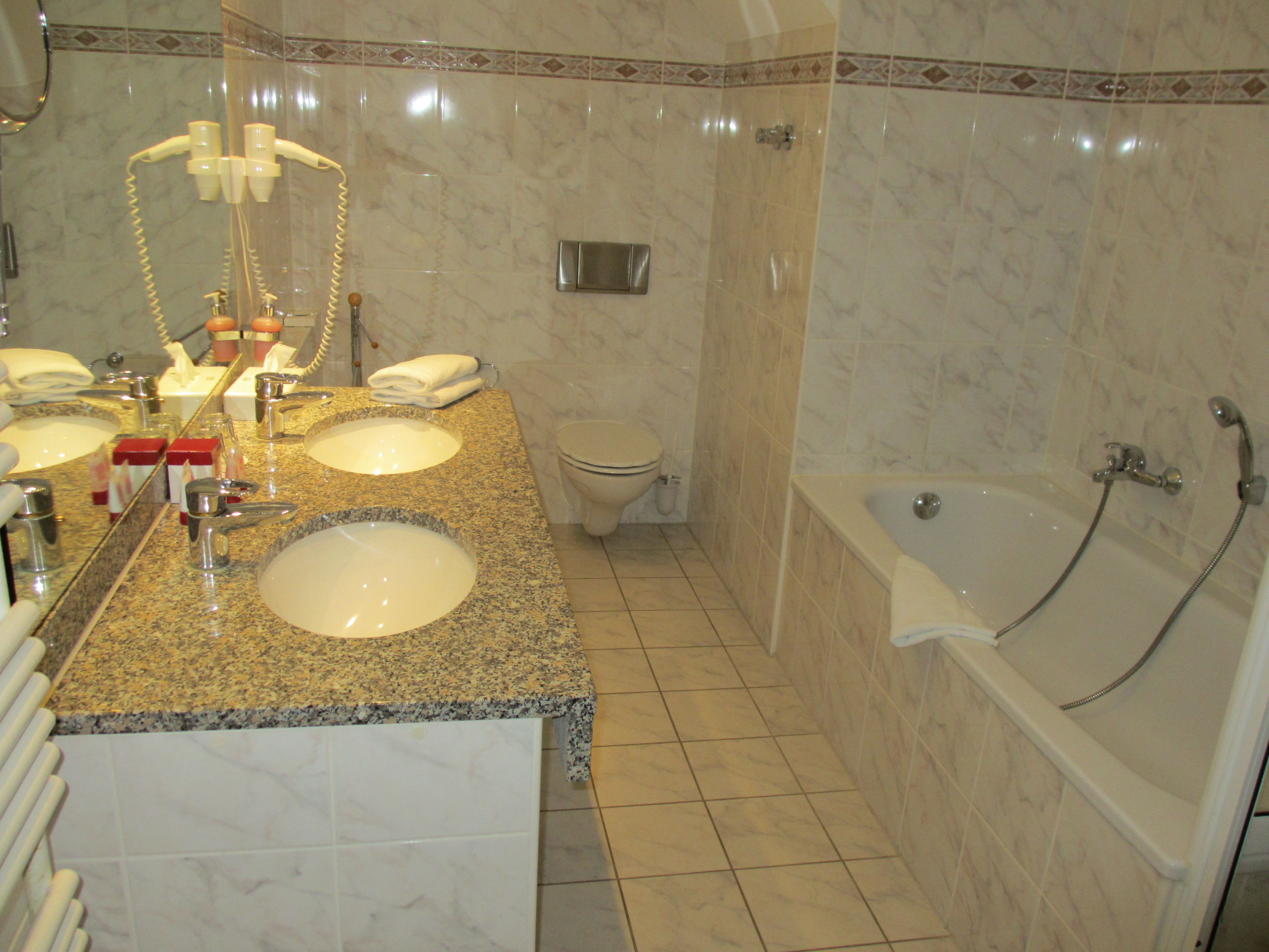 A bathroom with two sinks, a toilet, and a bathtub.
