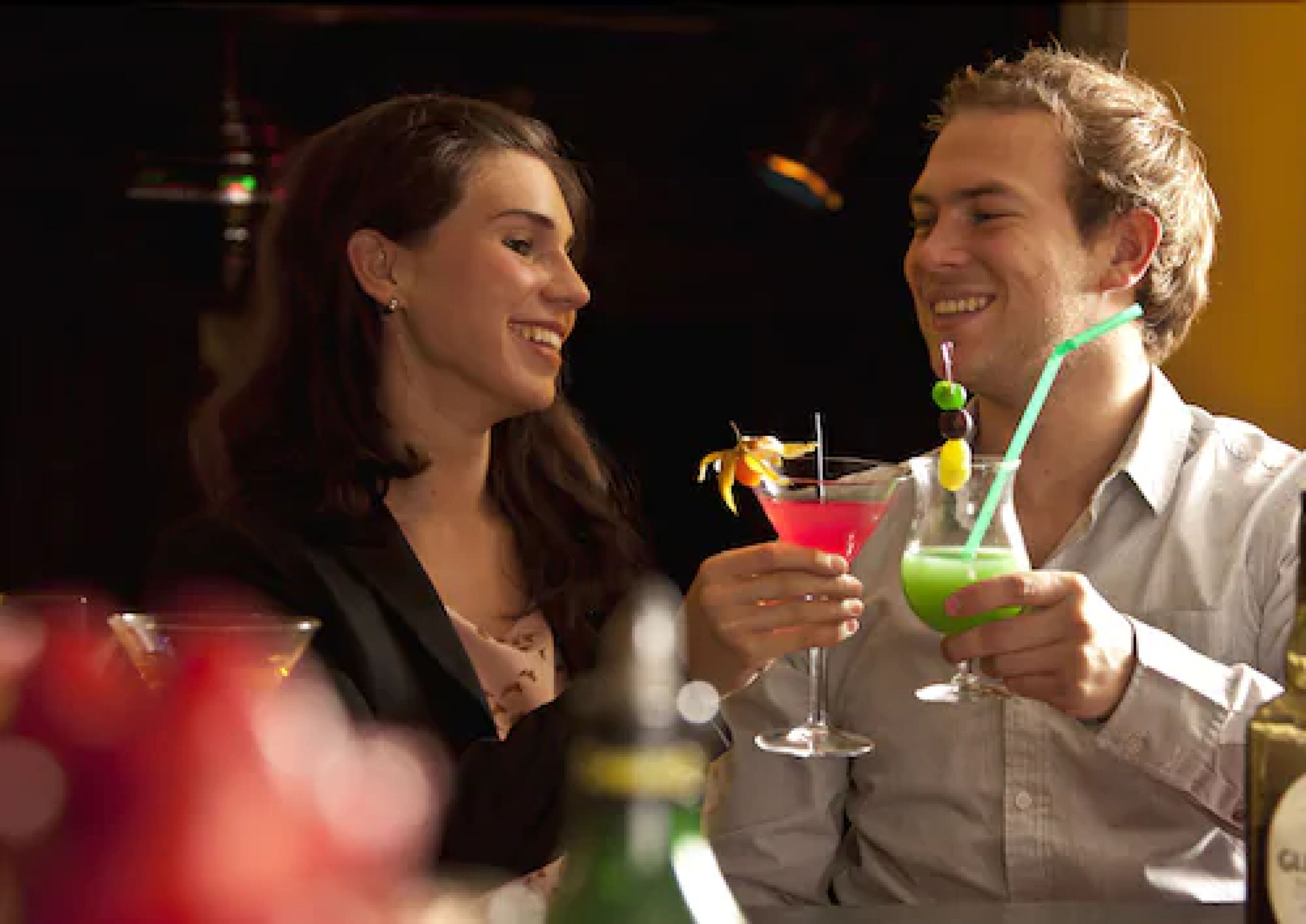 Dos personas sentadas en una mesa con bebidas.