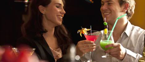 Dos personas sentadas en una mesa con bebidas.