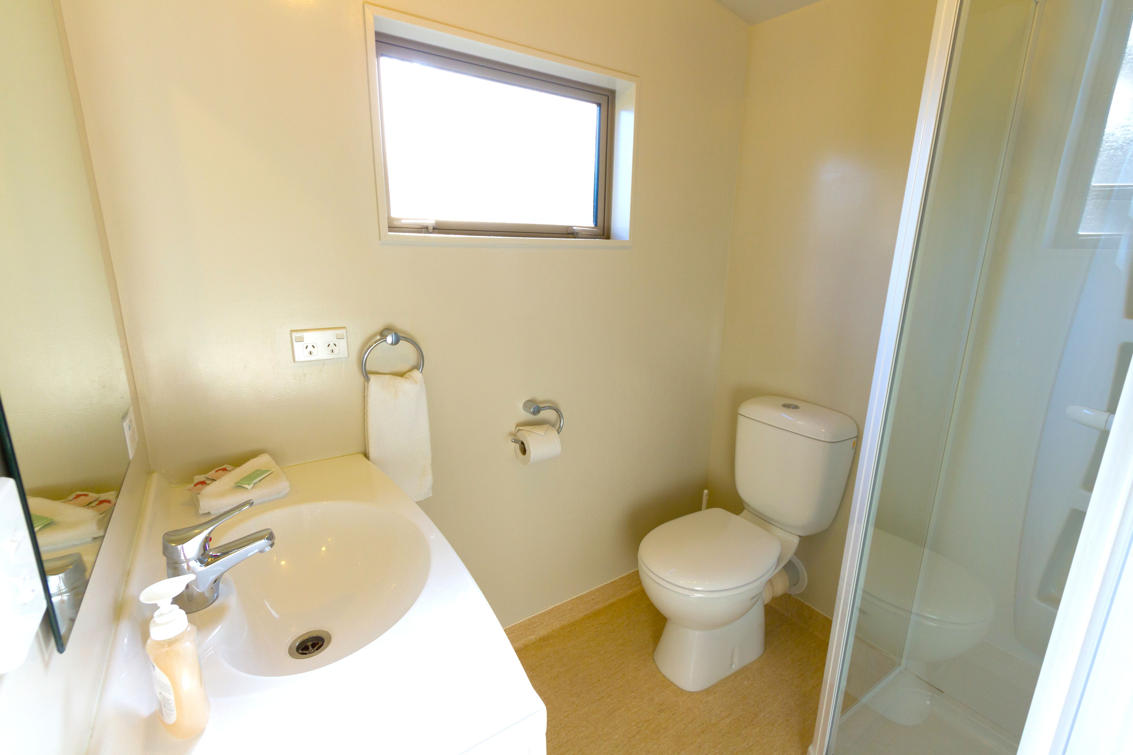 Un baño con lavamanos, inodoro y ventana.