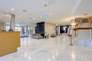 A spacious lobby with a reception desk, seating area, and a staircase. - Seminaris Sunday Hotel Bad Honnef (Bad Honnef)