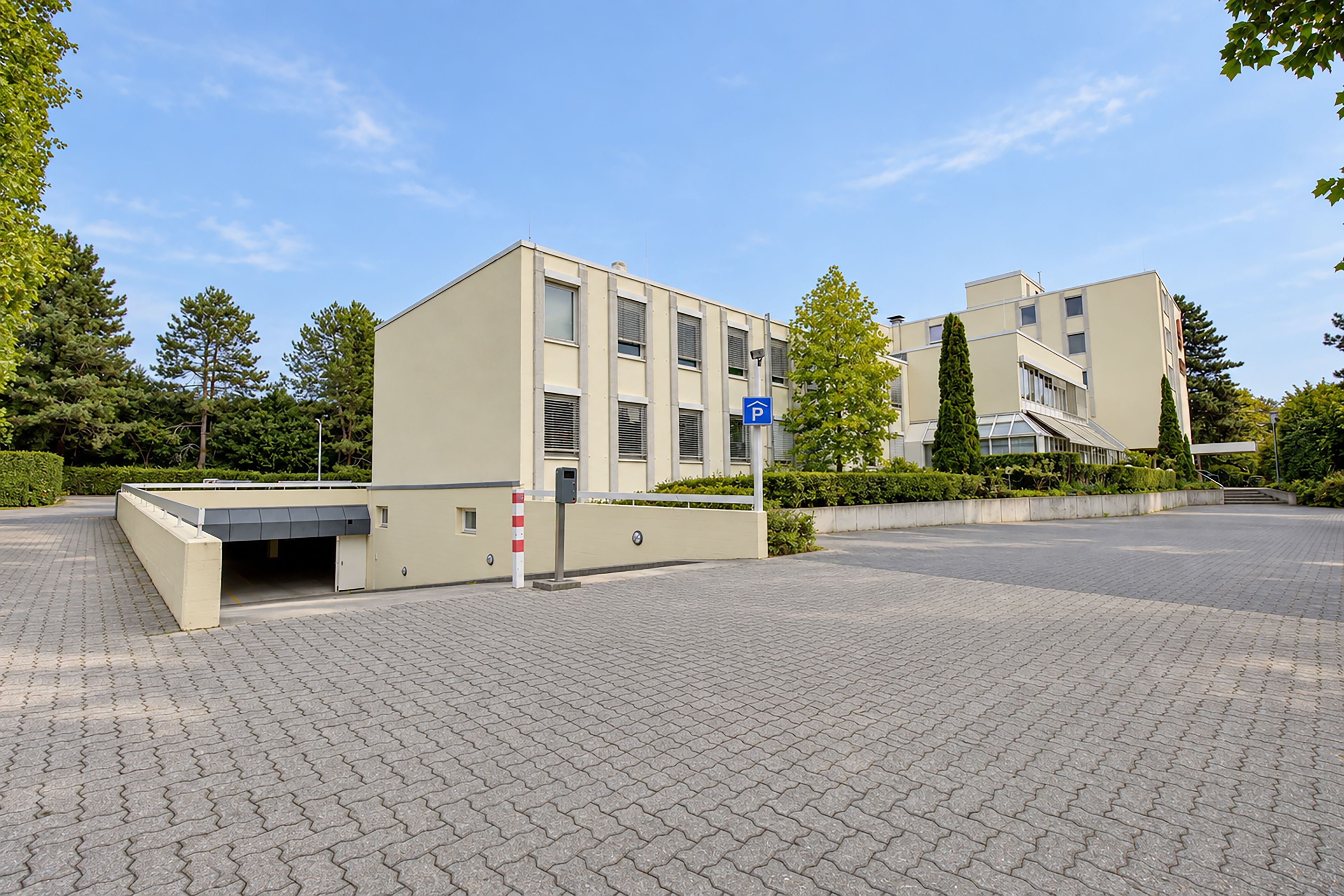 Ein modernes Gebäude mit Parkplatz und Fußgängerweg.