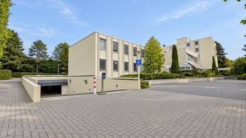 Ein modernes Gebäude mit Parkplatz und Fußgängerweg.