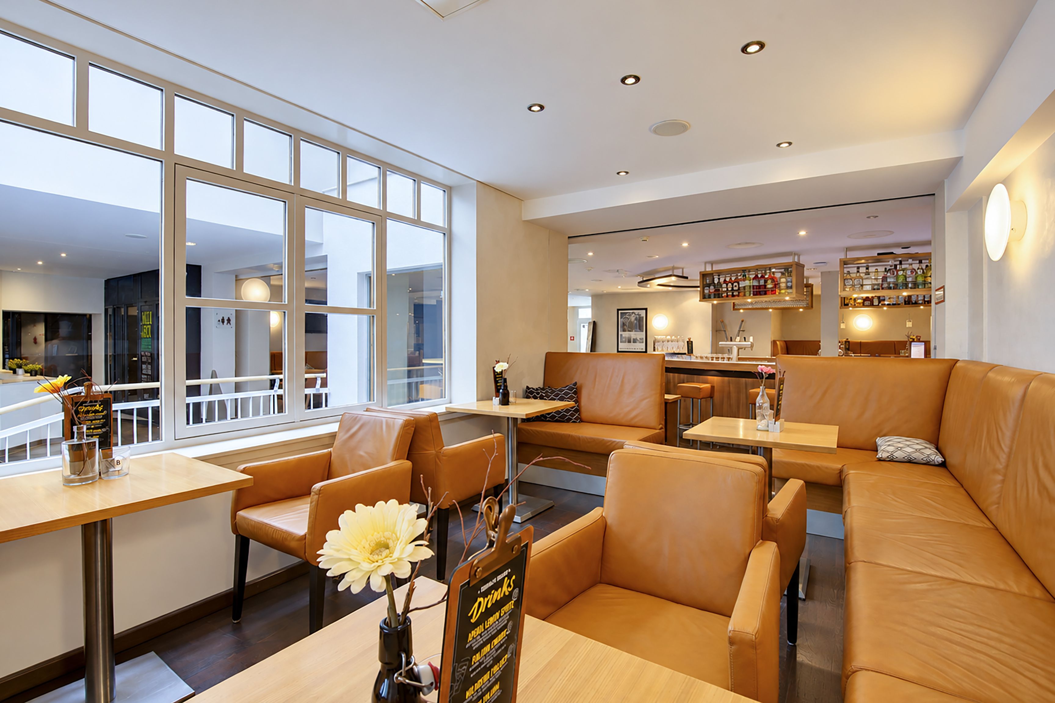 Ein modernes Interieur mit Sitzbereichen, Tischen und einer Bar.
