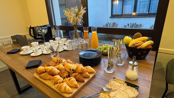 A breakfast buffet with croissants, fruits, and juice. - The Originals City, Le Patio, Cholet Nord (Beaupreau-en-Mauges)
