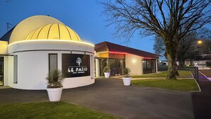 A modern hotel with a dome-shaped building and a flat-roofed structure. - The Originals City, Le Patio, Cholet Nord (Beaupreau-en-Mauges)