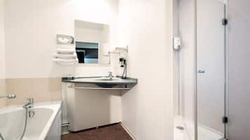 Un baño moderno con bañera, lavabo y cabina de ducha de vidrio.
