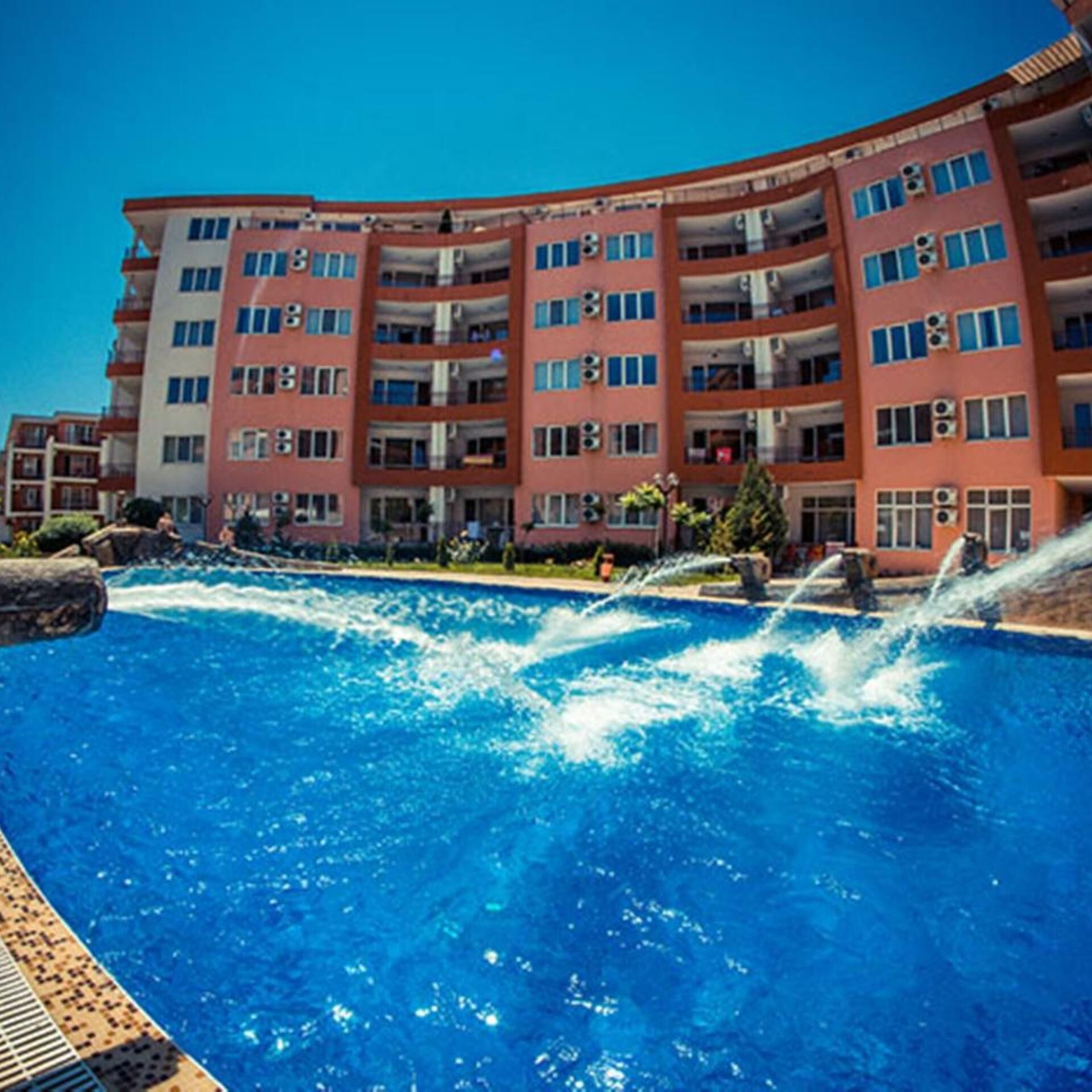 Un hôtel à plusieurs étages doté d’une piscine et agrémenté d’une fontaine.