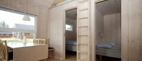 Una habitación con literas, un escritorio y una silla.