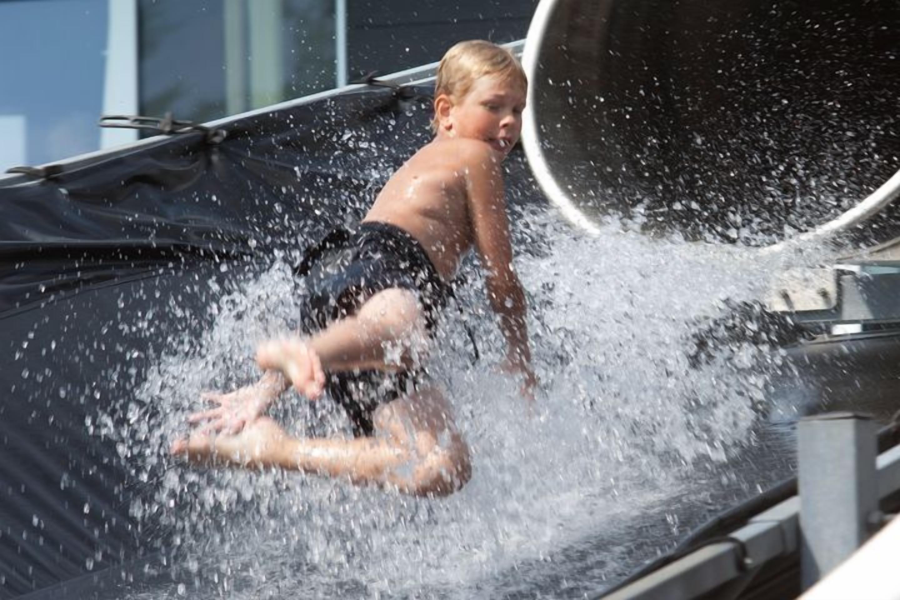 A child sliding down a water slide.