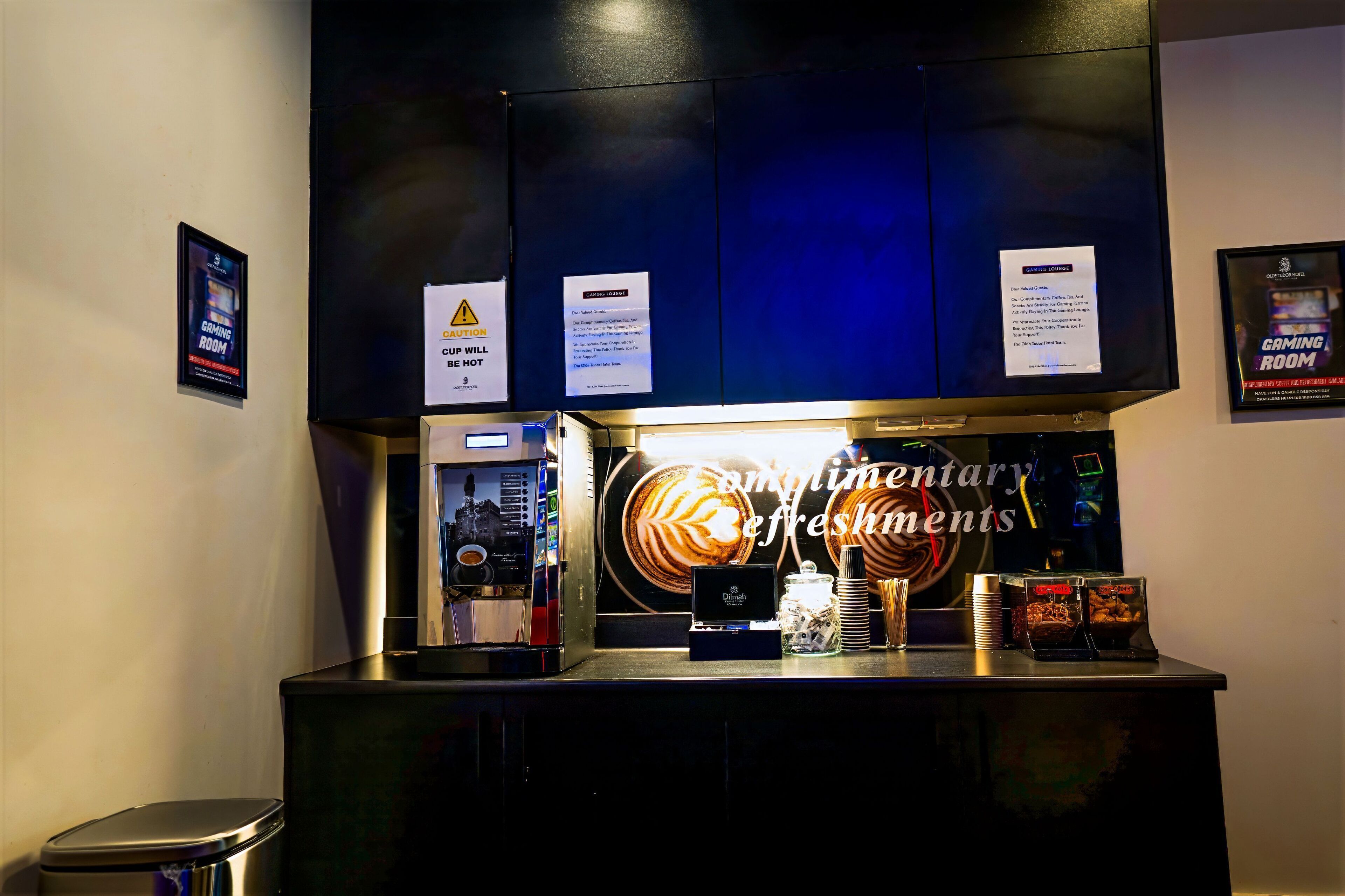 A coffee machine and a coffee cup on a counter with a warning sign above.