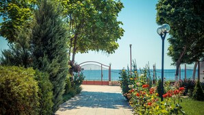 A paved pathway leading to a gate with a view of the sea. - Riviera Fort Beach (Ravda)