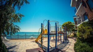 A playground with a slide and climbing structures, overlooking a beach and the sea. - Messambria Fort Beach (Elenite)