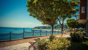A coastal view with a wooden deck, a fence, and a tree overlooking the sea. - Messambria Fort Beach (Elenite)