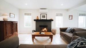 A living room with a fireplace, a sofa, a coffee table, and a cabinet.