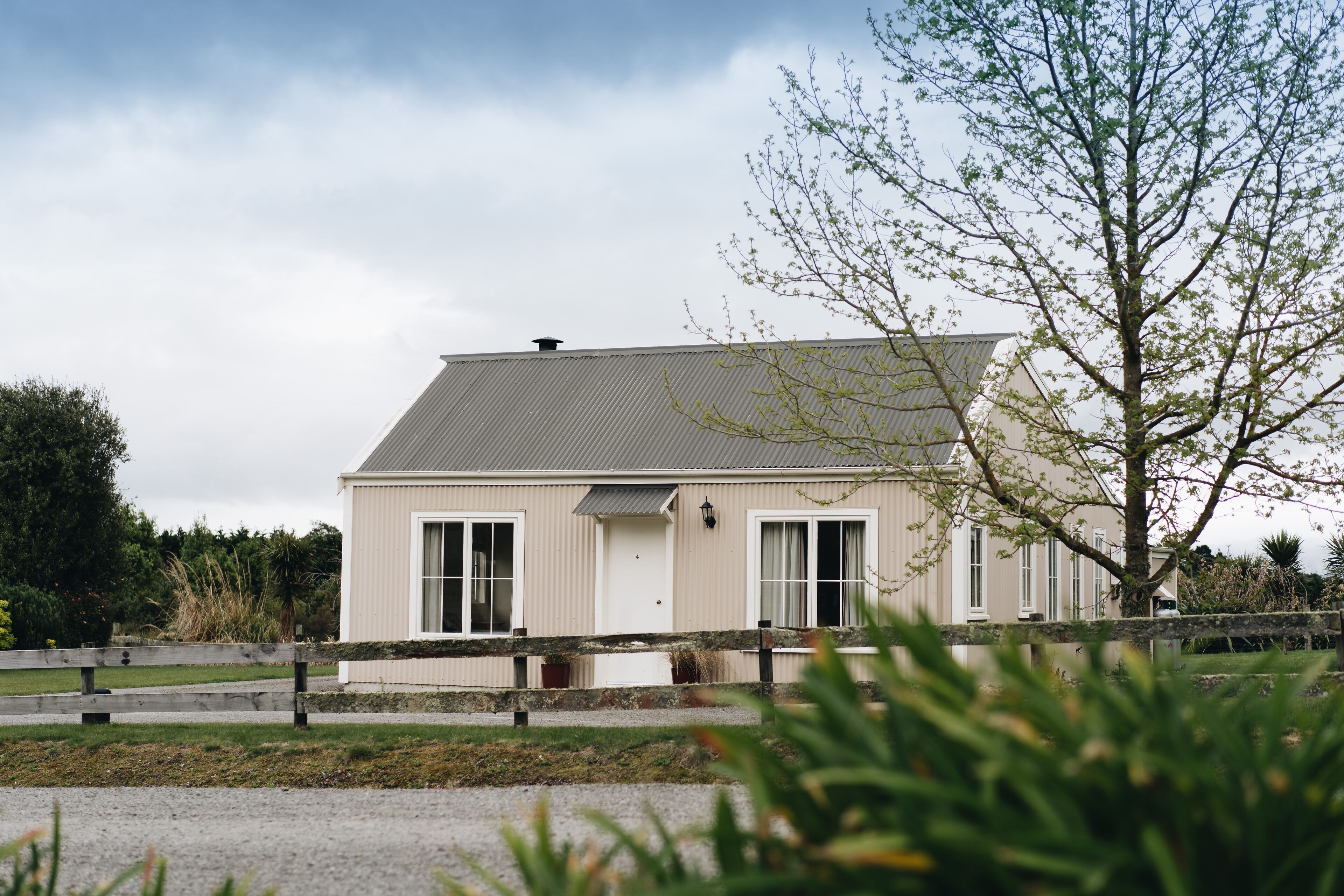 A single-story building with a sloped roof, large windows, and a small porch area.
