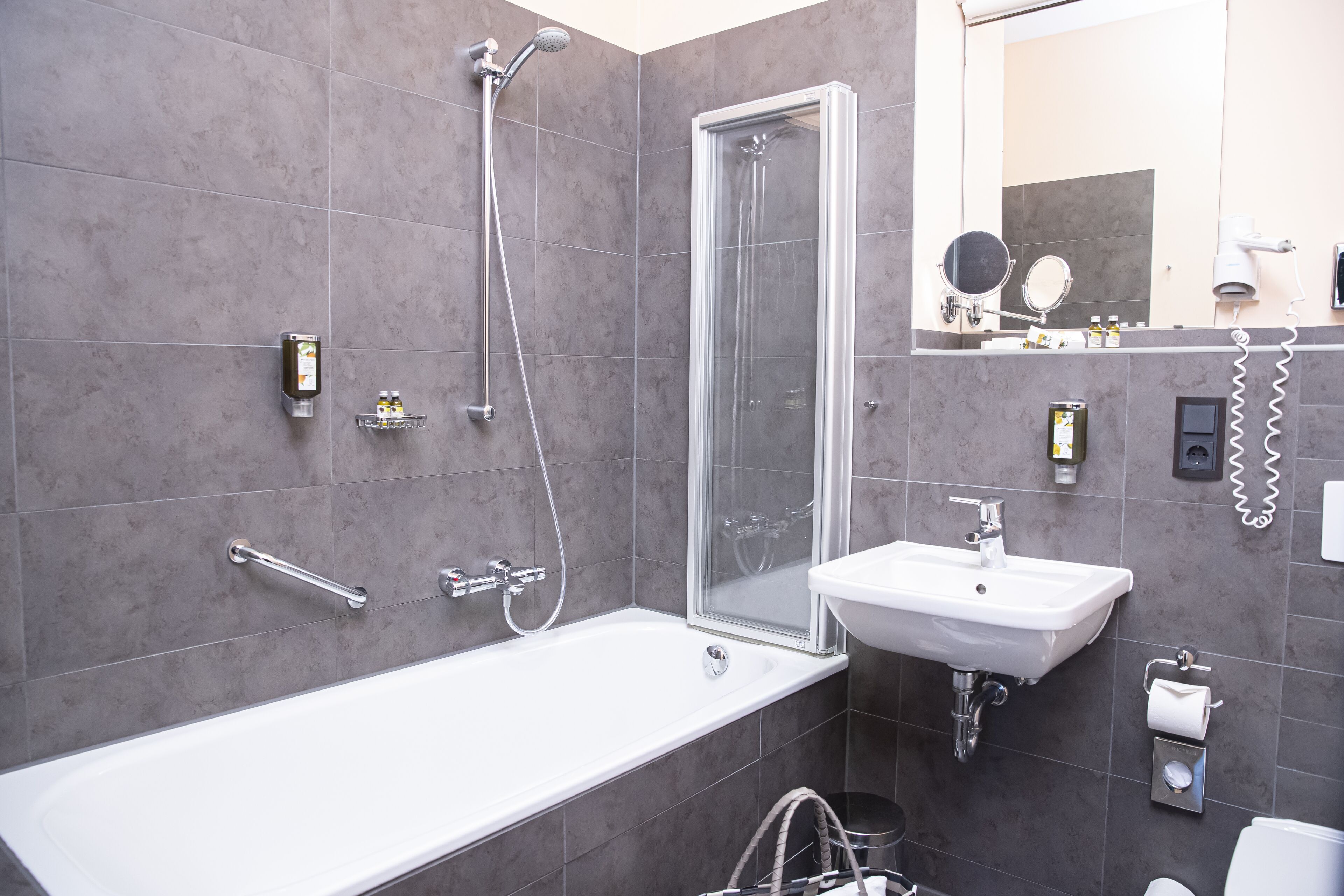 A modern bathroom with a bathtub, shower, and sink.