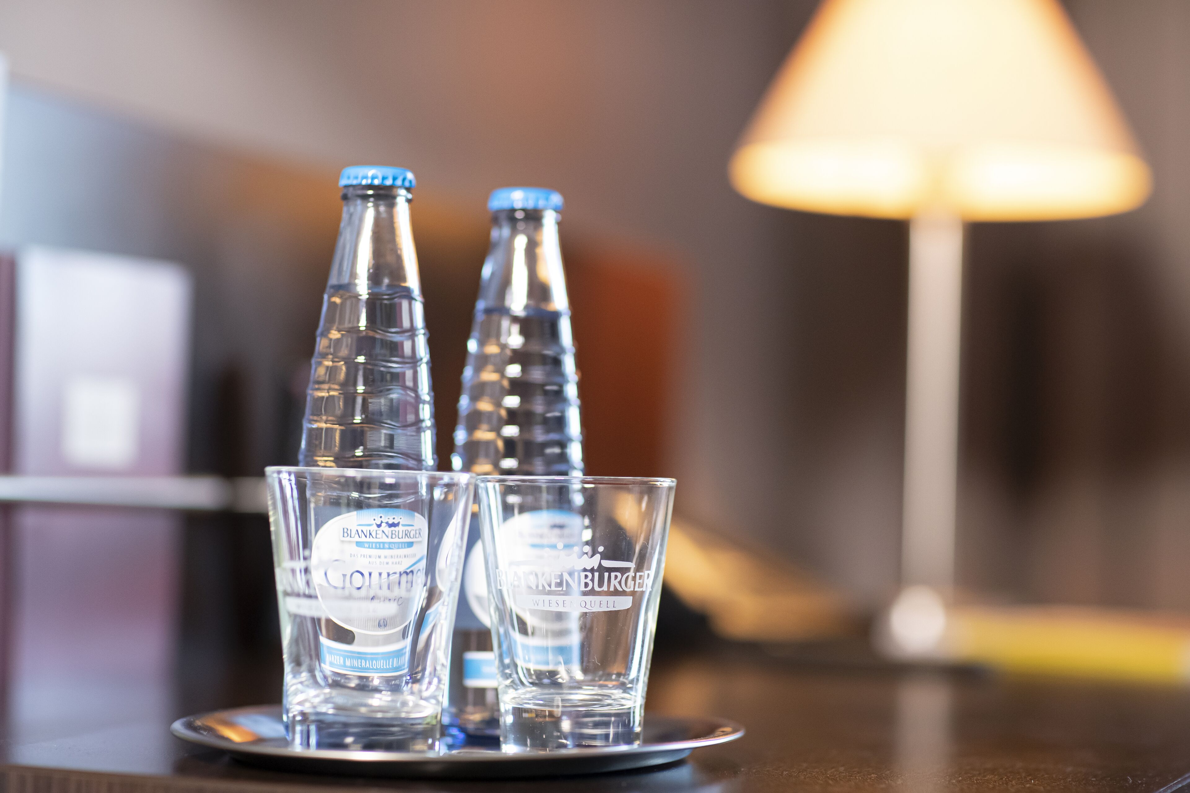 Three bottles and two glasses on a tray.