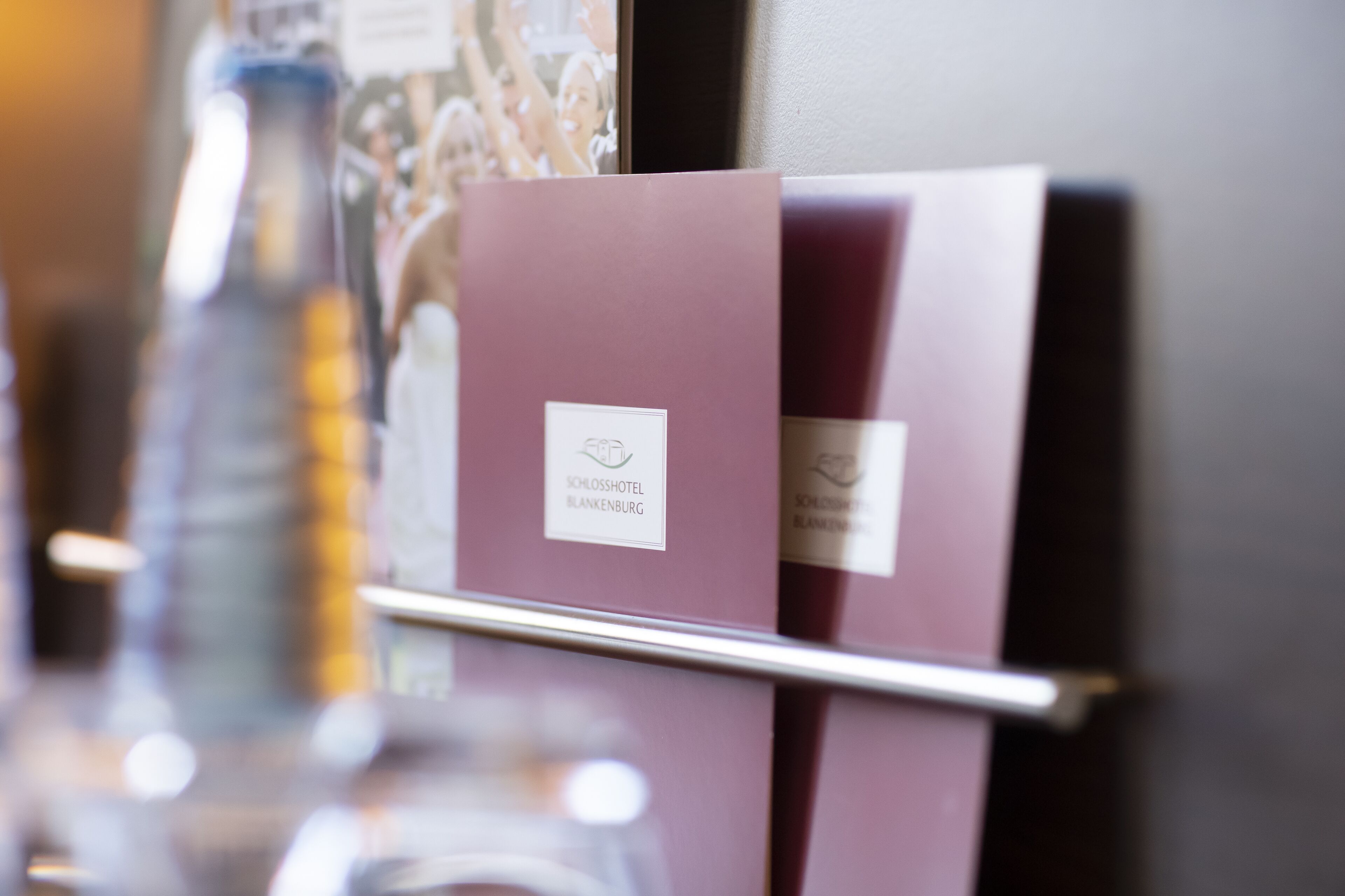 A close-up of a hotel brochure with the name "Schlosshotel Blankenburg" visible.