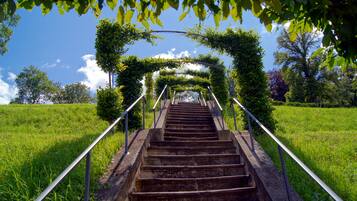 Un conjunto de escaleras exteriores con barandillas metálicas, rodeado de follaje y árboles.