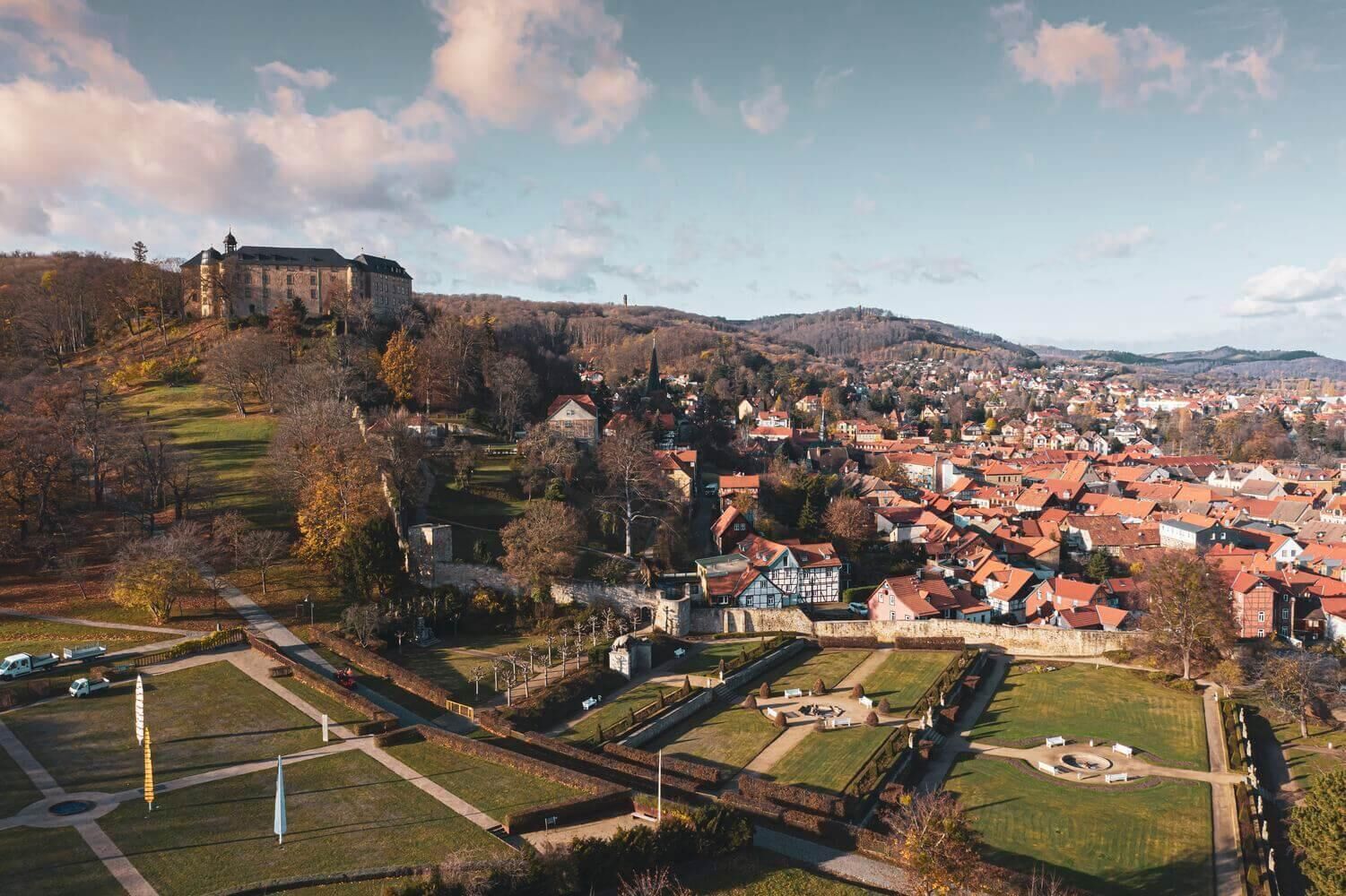 A historic town with a prominent castle on a hill, surrounded by residential buildings and well-maintained public spaces.