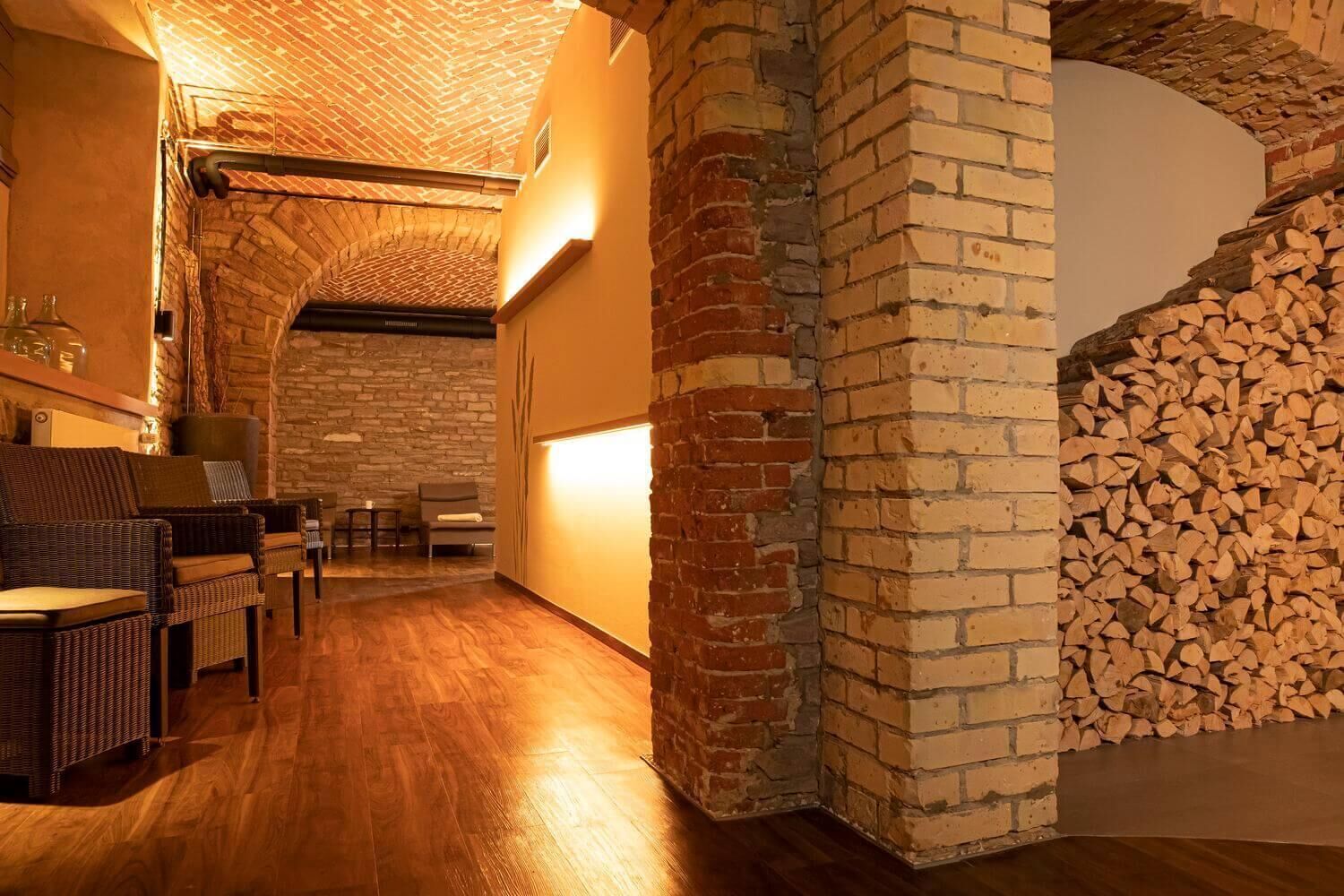 Ein gemütliches Zimmer mit Kamin aus Backsteinen, Holzböden und Korbmöbeln.