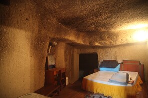 Ein rustikales Zimmer mit einem hölzernen Bett, einem Schreibtisch und einem Stuhl.