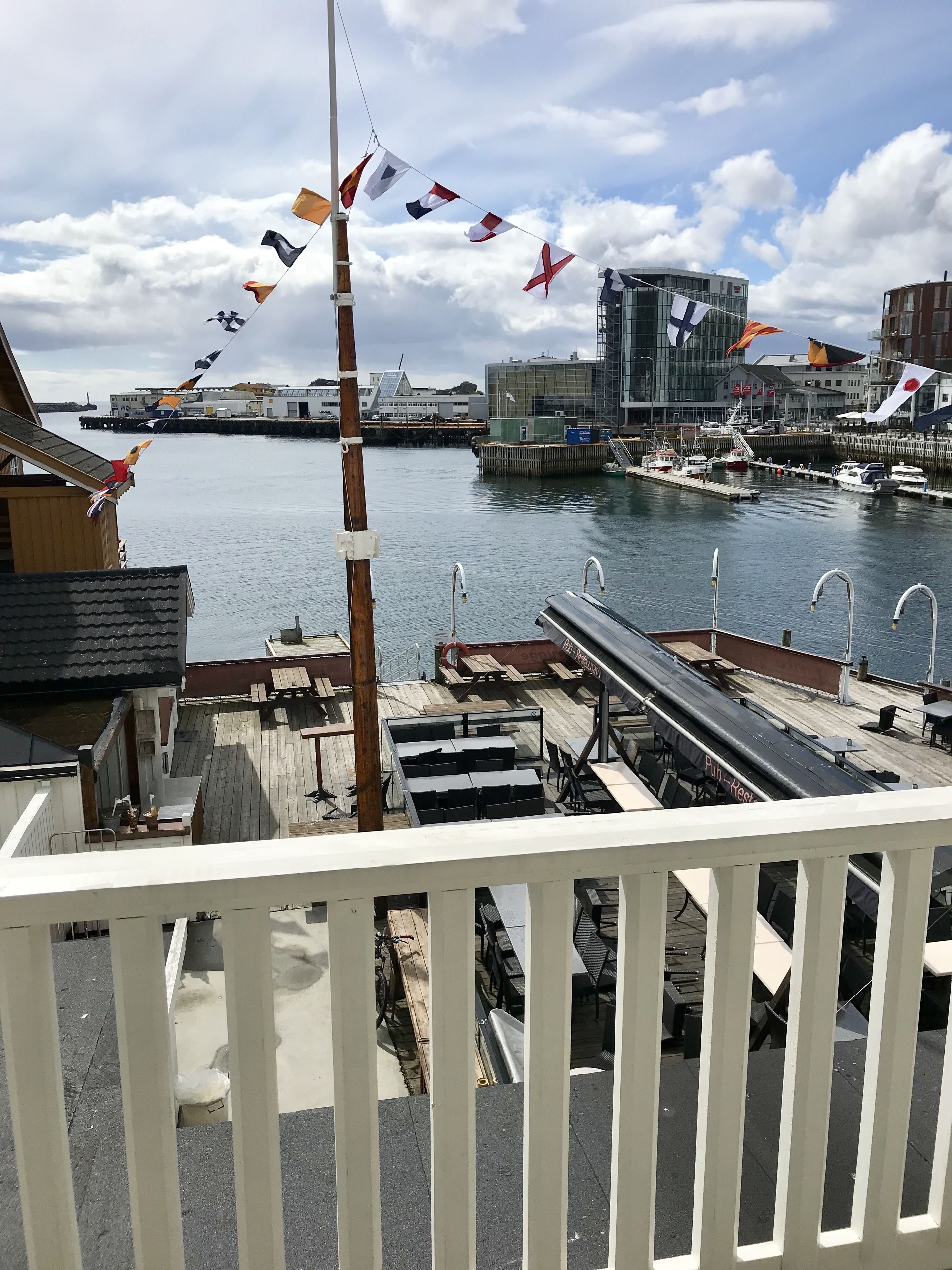 A waterfront view with a dock, boats, and buildings in the background.