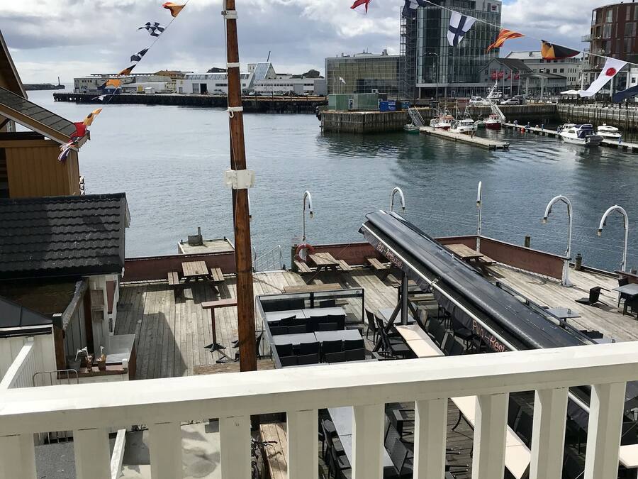 A waterfront view with a dock, boats, and buildings in the background.