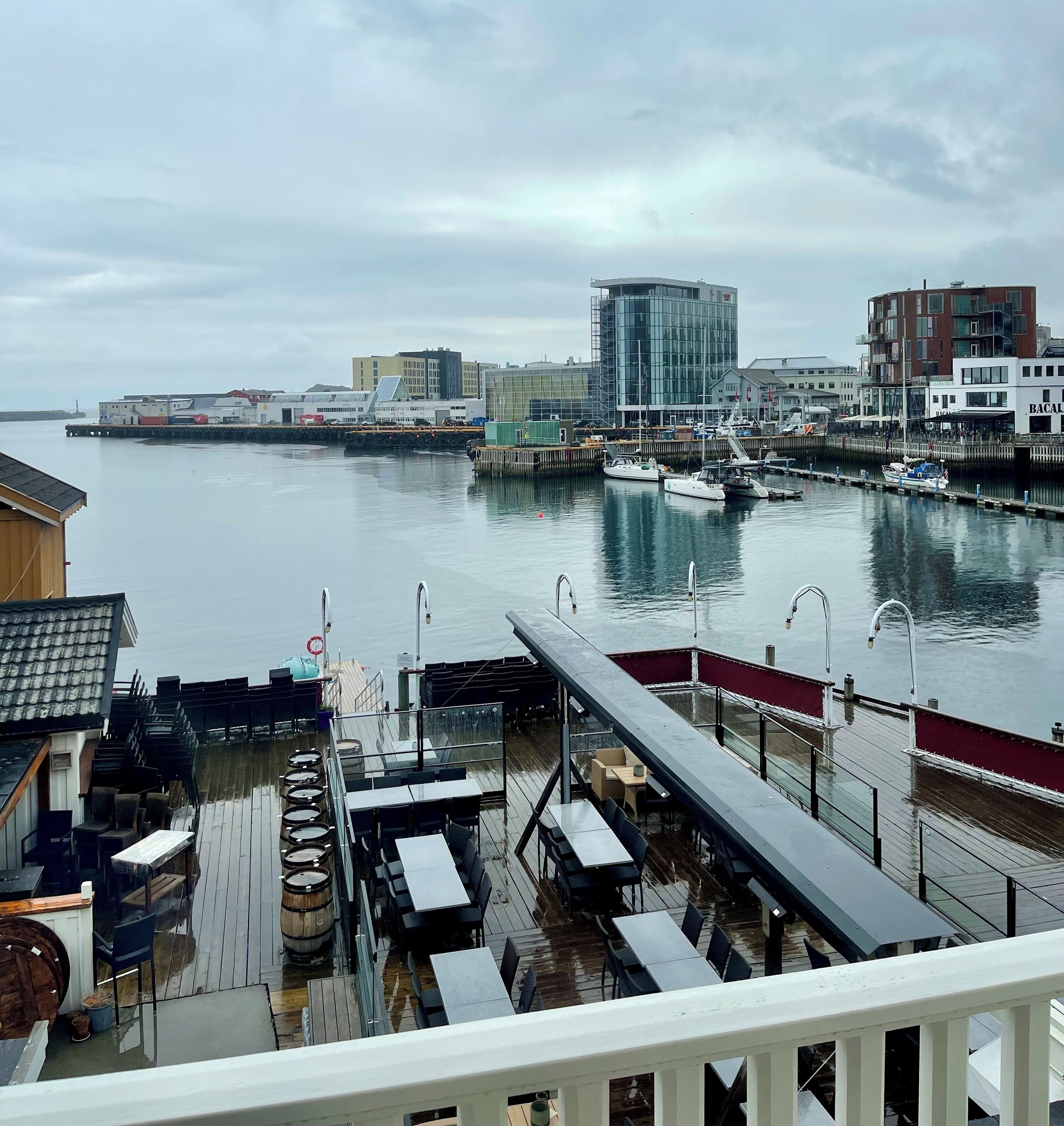 A waterfront restaurant with outdoor seating overlooking a marina.
