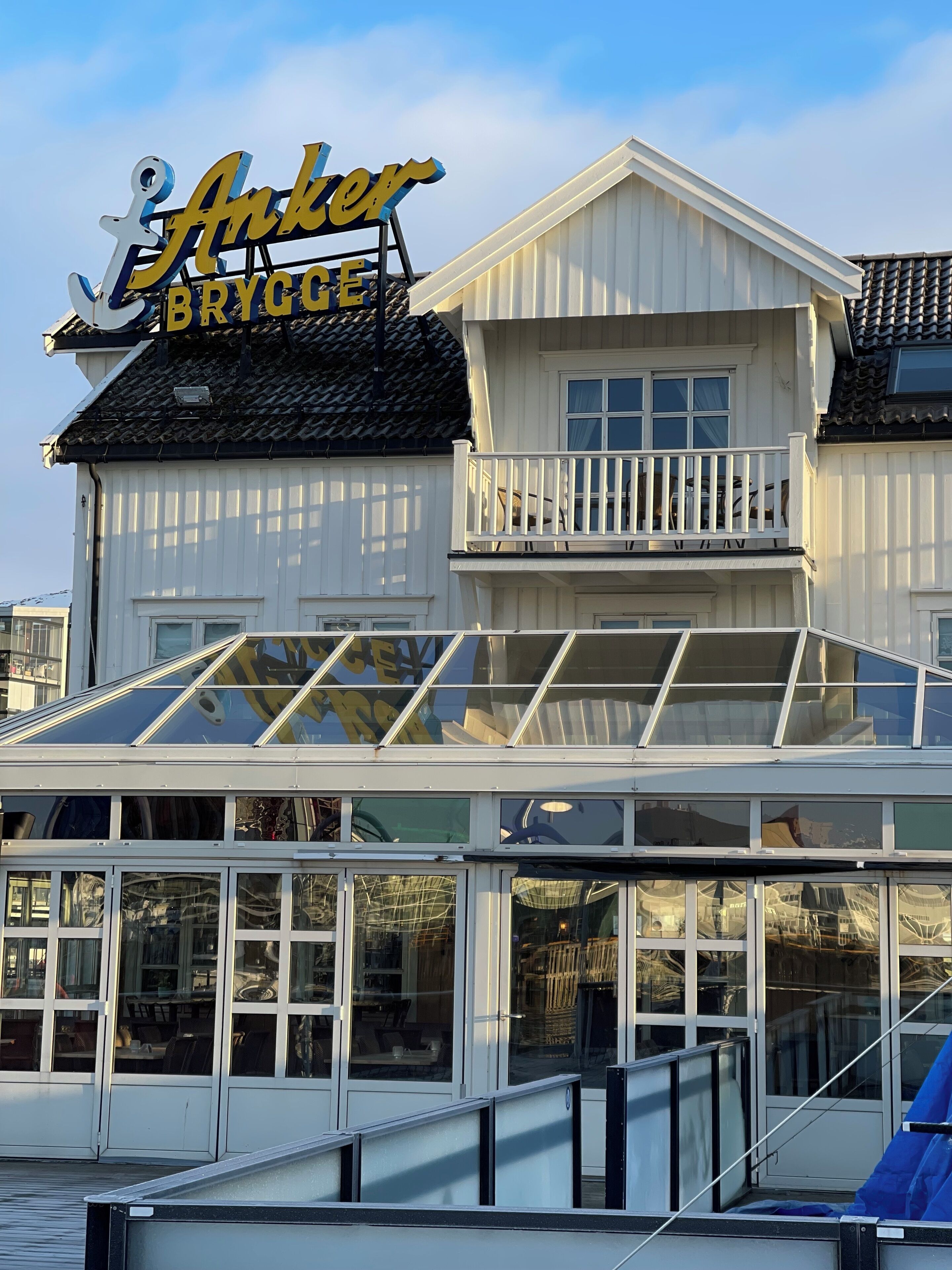A building with a sign reading "Anchor Brygge" and a balcony with railings.